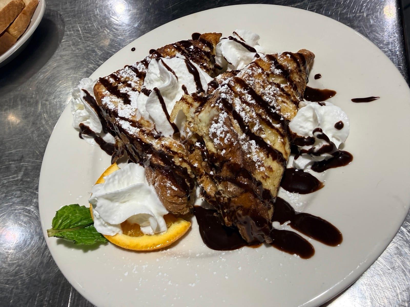 Stuffed French toast with chocolate drizzle and whipped cream at Ranch House Makarios in Vestavia Hills, AL